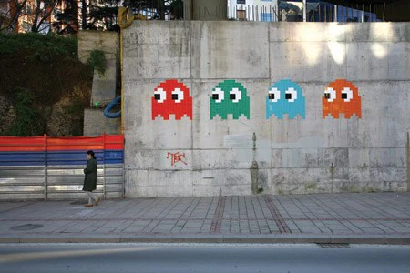 Invader, untitled pixel mosaic installation. The French artist's work appears alongside Fairey and Damien Hirst in "Triple Trouble," underscoring shared strategies of branded repetition and public spectacle.